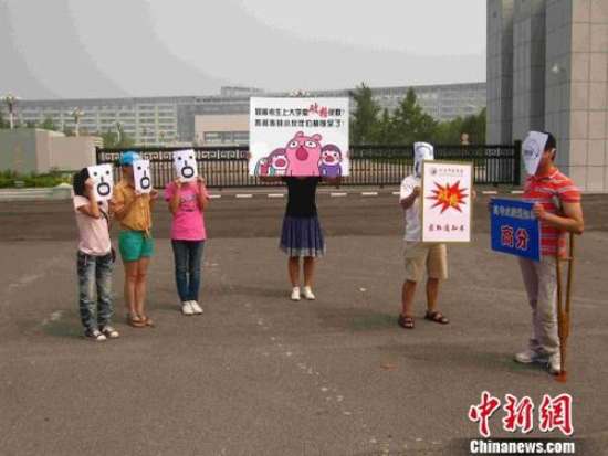 图为：2013年8月13日，在河南中医学院门前，6名市民自发组织起来表演行为艺术，呼吁高校给予残障人士平等的入学机会。