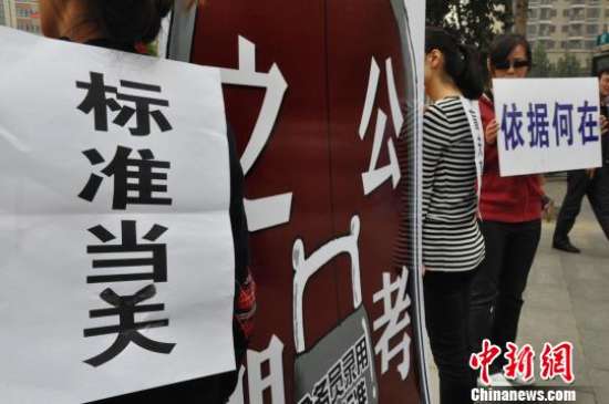 图为：2013年10月15日，郑州市3名热心公益的女大学生在广场上演了名为“标准当关，盲夫莫开”的行为艺术。