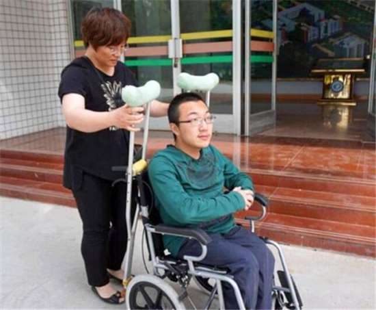 8.甘肃轮椅考生给清华的一封信成热点.jpeg.jpg 图为:妈妈推着坐在轮椅上的魏祥走在街上。