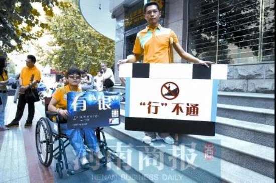 DAY4.jpg 图为:张宁,宋强,黄生在表演行为艺术:在银行门外的台阶上,一人高举着放大版的“银行卡”,上写“有