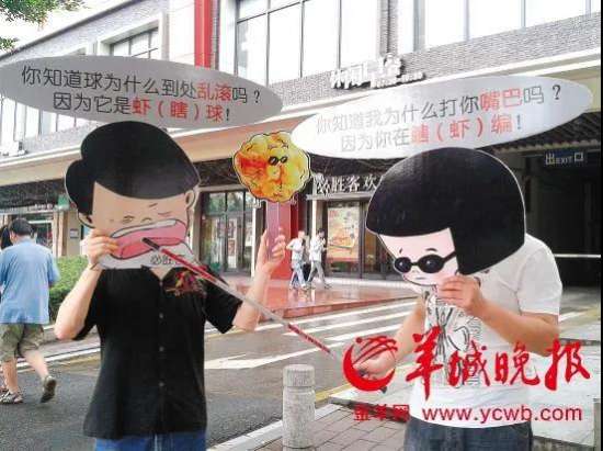 3广州市的两名视障人士广州海珠区客村地铁站旁边的必胜客欢乐餐厅丽影店开展一场“巧对‘虾(瞎)说’”行为艺术.jpg 图为:广州市的两名视障人士广州海珠区客村地铁站旁边的必胜客欢乐餐厅丽影店开展一场“巧对‘虾 *(瞎)* 说’”行为艺术,矛头直指背后的必胜客欢乐餐厅。具体对白为:你知道球为什么到处乱滚吗?因为它是虾 *(瞎)* 球!你知道我为什么打你嘴巴吗?因为你在瞎 *(虾)* 编!